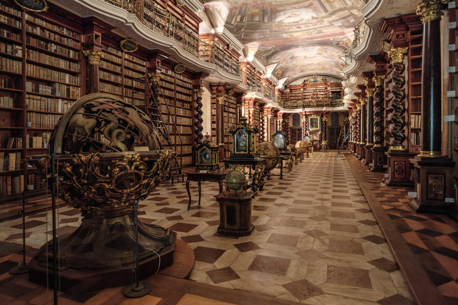 Interior of the Clementinum Baroque Library Hall in Prague, seen from the entrance with historical globes on the floor